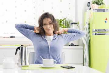 Tired woman having breakfast at home