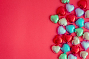 Obraz premium Red background with multicolored heart rests in the concept of Valentine's Day.
