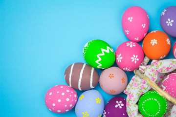 Easter eggs in a basket weave wood on the sky background.