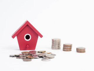 Money coins stack growing with red house on wood background. Business growth investment and financial concept ideas.Real estate investment. House and coins on table.Save money with stack coin.