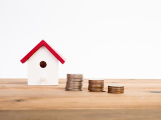 Money coins stack growing with red house on wood background. Business growth investment and financial concept ideas.Real estate investment. House and coins on table.Save money with stack coin.