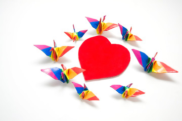Rainbow origami bird on heart shape sign of freedom, Gay conceptual images