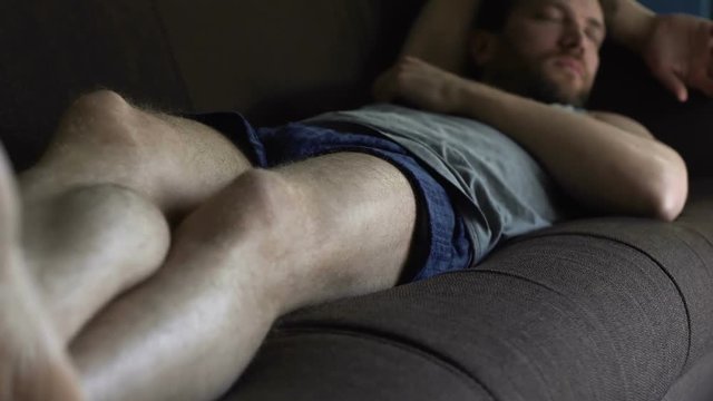 Untidy drunk male in boxers sleeping on sofa, relax time of single man at home