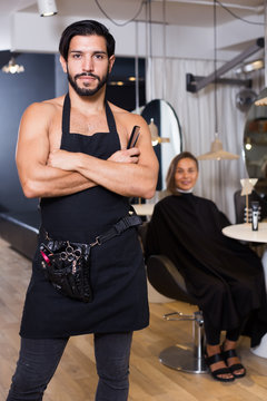 Portrait of sexy adlult male hairdresser standing