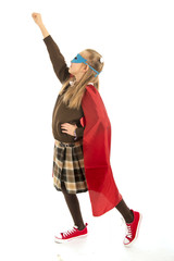 7 or 8 years old young female child in super hero costume over school uniform  performing happy and excited isolated on white background
