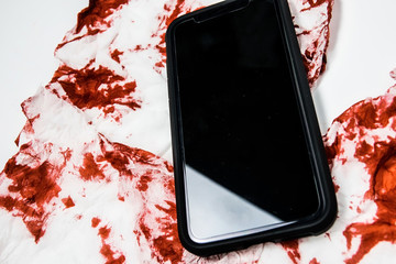 Cyber criminal scene, Smartphone over detail of blood texture, social media addiction