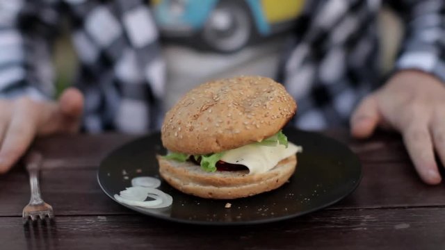 hungry man and a hamburger. men's hands hold a burger