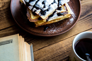 a cup of tea and a pile of wafers and book