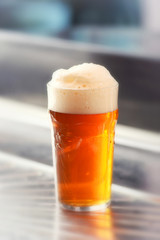 Fresh served pint of frothy draft beer in a glass
