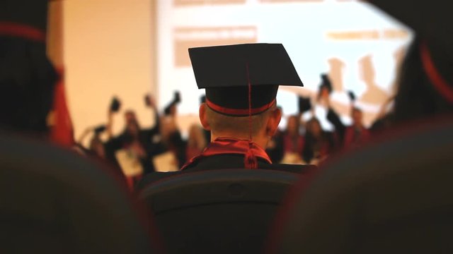 Graduation view, graduates with gown waiting,  happy people rising up gown cap