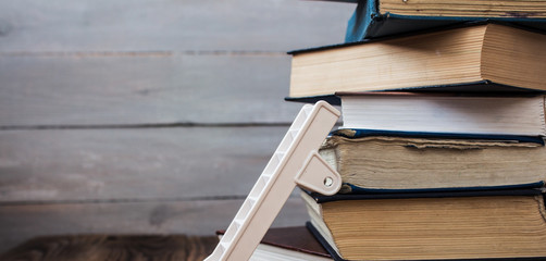 ladder on pile of old books on wooden background