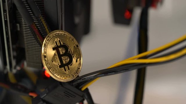 bitcoin on the background of a graphics card in a rack for crypto-currency mining