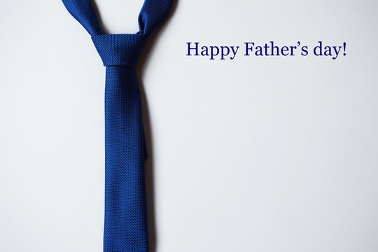 Bright blue tie on light blue background. Happy Fathers Day pattern for greeting card. Top view image with copy space for text.