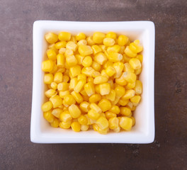 Sweet canned corn in white bowl. Ingredients for salad. Selective focus.