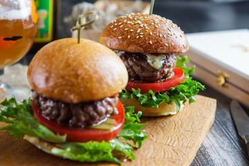 Tasty and appetizing hamburger cheeseburger on a wooden board
