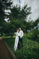 Romantic wedding moment, couple of newlyweds smiling portrait, bride and groom hug while on a walk in the park