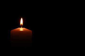 Candle flame in the darknes. Burning candle.