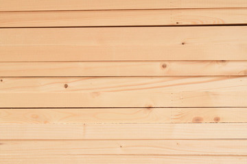 Obraz premium Texture of folded wooden planks in a warehouse with a forest. View from the end