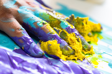Fingers and hand dipped in colorful paint
