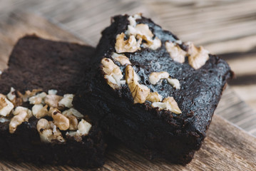 Pieces of delicious chocolate brownies on a wooden background