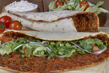 Turkish Food: lahmacun closeup on a wooden table. Horizontal
