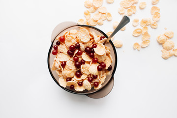 delicious crispy cornflakes with cranberries in bowl on white background, closeup, healthy breakfast 