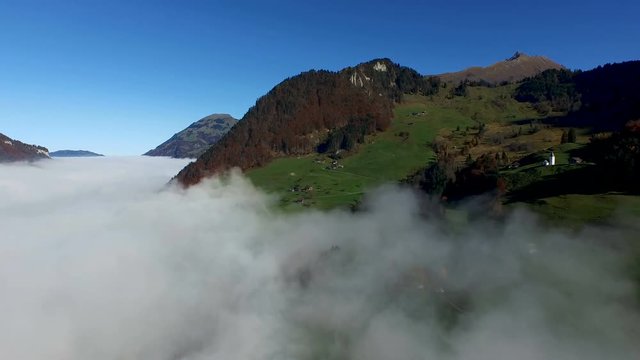 Aerial view in the valley of Engelberg in the foothills of Switzerland on an autumn day with a sea of fog