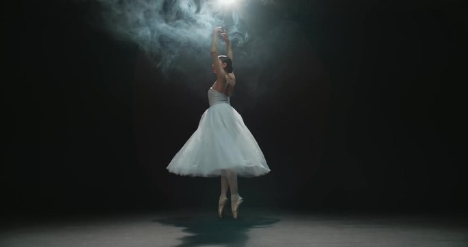 4K video footage beautiful elements of classic ballet ballerina dancing on black background, slow motion