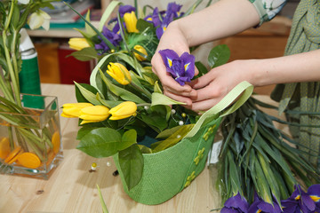 Hands of florist making bouquet spring flowers.