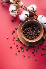Obraz na płótnie Canvas cup of black coffee, coffee beans and cotton flowers on dark background 