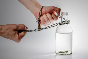metal chain in the hands of the wind a bottle of alcohol