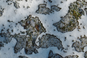 Schneeflecken auf einer Wiese
