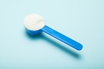 Milk powder in a measuring spoon.