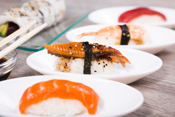 four kinds Nigirisushi on oval saucers and Uramaki