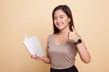 Young Asian woman thumbs up with a book.