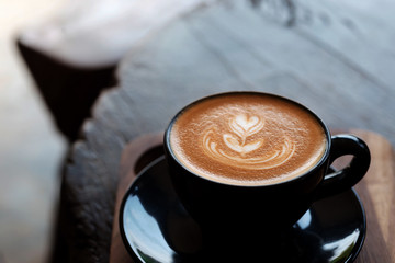 a cup of hot latte coffee on wooden table