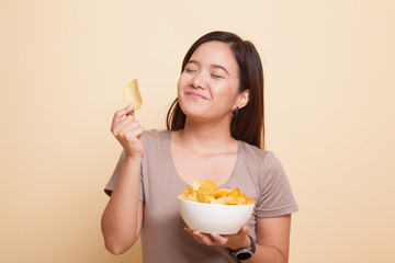 Young Asian woman eat potato chips.