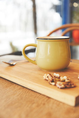 Hot cocoa in mug with nuts served on wooden board