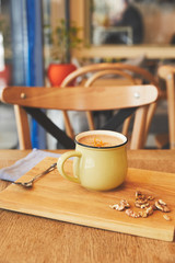 Cocoa drink with orange peel and nuts on table