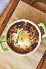 Berry crumble served in pot with ice cream