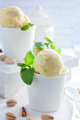 Homemade pistachio ice cream in white cups, selective focus