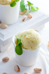 Homemade pistachio ice cream in white cups, selective focus