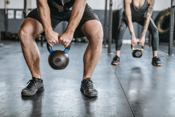 Obraz na płótnie Canvas Sportsmen and Sportswomen Lifting Weights at Gym