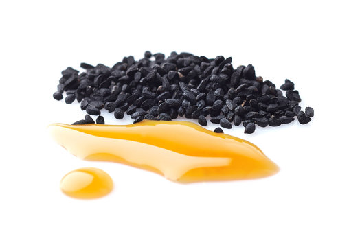Black cumin oil with seeds on white background