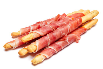 Bread sticks grissini with prosciutto isolated on white background