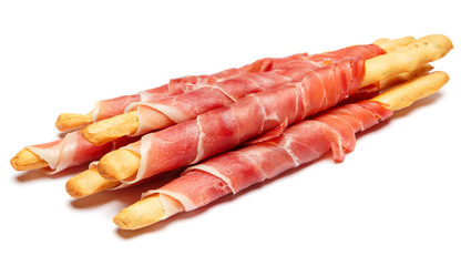 Bread sticks grissini with prosciutto isolated on white background