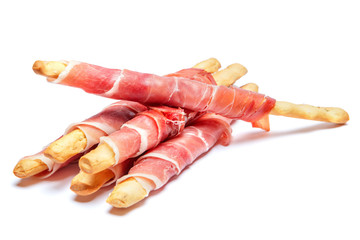 Bread sticks grissini with prosciutto isolated on white background