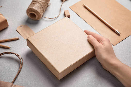 Woman Holding Blank Box On Grey Background. Mockup For Design