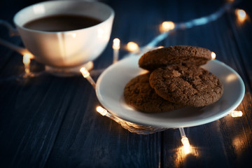 Plate with delicious oatmeal cookies and cup of coffee on table
