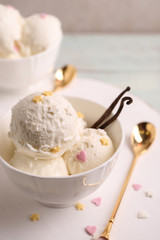 Cup with delicious vanilla ice cream on table